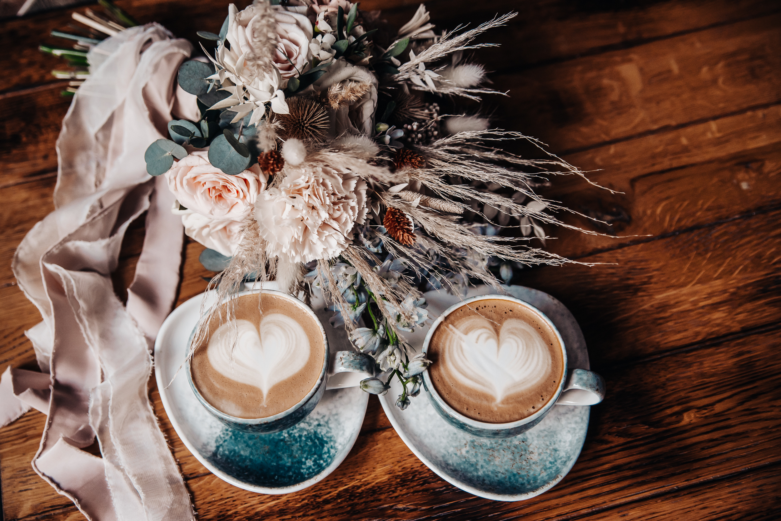 Coffee in beautiful cups with foam, hearts and flowers. Valentin